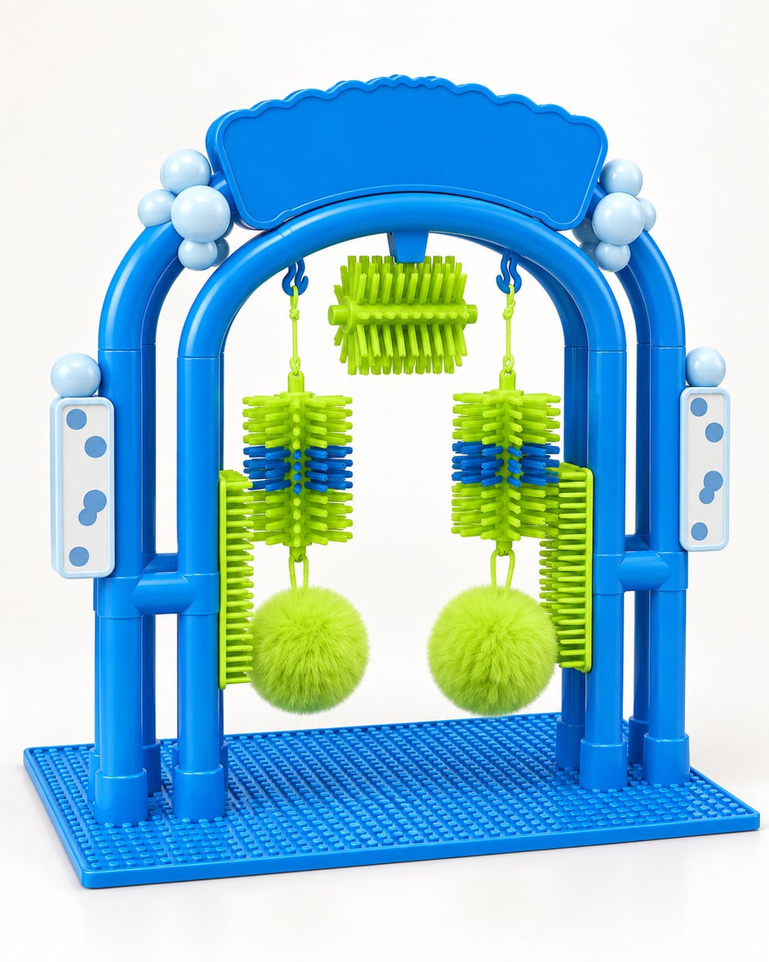 The Purr Thru self-grooming arch: a blue arch on a textured mat with green bristle brushes and pom-poms